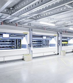 Moderne lager- eller produksjonsområde med automatiserte reoler og industrielt utstyr.